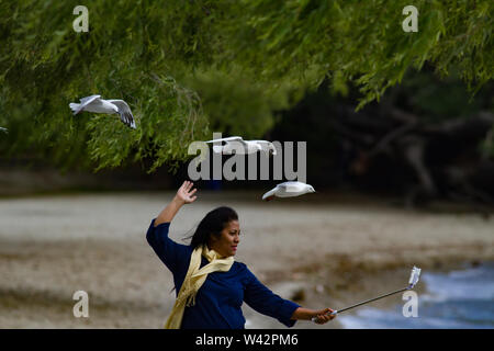 Donna con i gabbiani in volo flying overhead Foto Stock