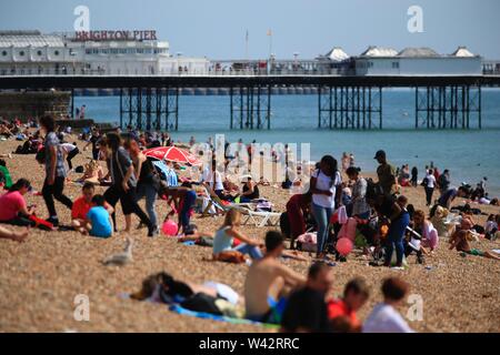 Decine di persone godetevi il sole e un clima caldo e durante le vacanze scolastiche estive sulla spiaggia di Brighton in East Sussex. 14 Agosto 2017 Foto Stock