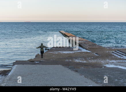 Odessa, Ucraina - 12.27.2018. Persone sole sul molo sul mare su una soleggiata giornata invernale Foto Stock