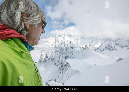 Un uomo nel suo fine degli anni cinquanta si affaccia su uno splendido paesaggio di montagna Foto Stock