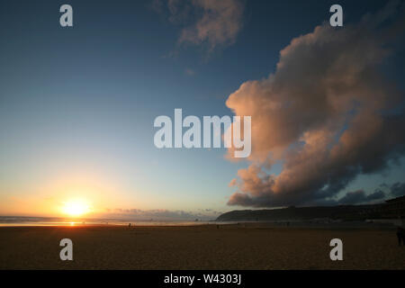 Un bellissimo tramonto costiera con rosa e arancio nuvole Foto Stock