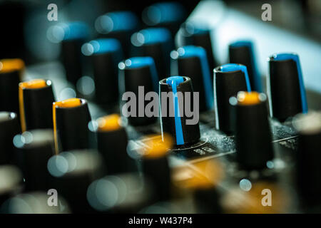 Close-up di volume e tono di manopole di controllo su un mixaggio audio desk Foto Stock