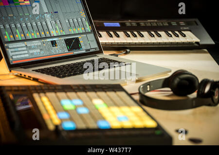 Musica elettronica di produzione. Apple Macbook con Ableton Live music software, spingere midi pad controller, le cuffie Beats e Yamaha Tastiera synth Foto Stock