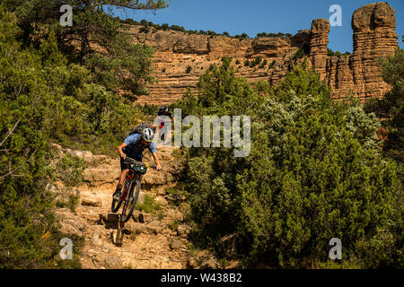 Due uomini giro in mountain bike verso il basso un ripido sentiero roccioso nella Sierra de Guara regione dei Pirenei Foto Stock