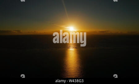 Cielo mattutino con le nuvole durante il sunrise. Sunrise al di sopra della superficie del mare con onde, vista aerea.Filippine. Sunrise oltre oceano. Foto Stock