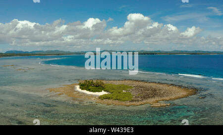 Antenna seascape: isola tropicale con palme e la spiaggia con la bassa marea contro il Cielo e nubi, vista aerea. Filippine, Siargao. Estate viaggi e concetto di vacanza Foto Stock