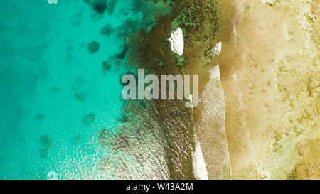 Oceano onde si infrangono sulla riva e Coral reef copia spazio per testo. vista aerea. Acqua di mare superficie in laguna con barriera corallina. Estate viaggi e concetto di vacanza. Foto Stock