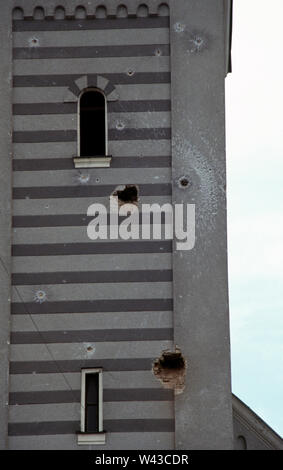 Il 12 aprile 1993 durante l'assedio di Sarajevo: bullet e buchi nella torre dell orologio della chiesa della Santissima Trinità a Sniper Alley (Zmaja od Bosne), in Dolac Malta area della città. Foto Stock