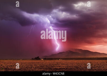 Fulmine colpire le montagne Dragoon come una tempesta monsonica si muove attraverso il sud-est Arizona al tramonto Foto Stock