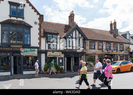 La gente camminare passato la Bugle Coaching Inn, un sedicesimo secolo inn si trova nella piazza, Yarmouth, Isle of Wight, England, Regno Unito Foto Stock