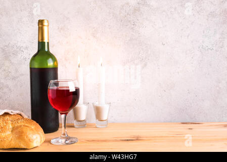 Lo shabbat o Shabath concetto. Challah pane, shabbat vino e candele sul tavolo, copia dello spazio. Tradizionale ebraica rito di Shabbat. Foto Stock