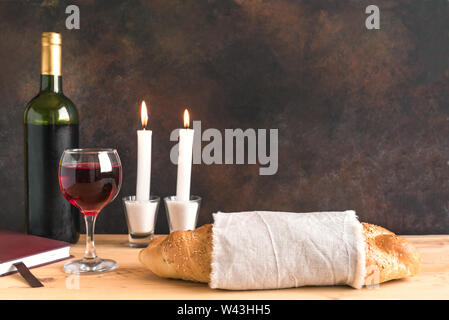 Lo shabbat o Shabath concetto. Challah pane e vino di shabbat, libro e candele su tavola, copia dello spazio. Tradizionale ebraica rito di Shabbat. Foto Stock