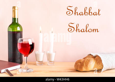 Lo shabbat o Shabath concetto. Challah pane e vino di shabbat, libro e candele su tavola, copia dello spazio. Tradizionale ebraica rito di Shabbat. Foto Stock