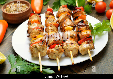 Appetitosi spiedini di pollo con i peperoni sulla piastra bianca Foto Stock