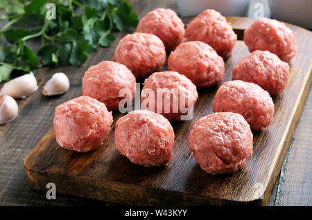 Materie polpette di carne su un tagliere, close up Foto Stock