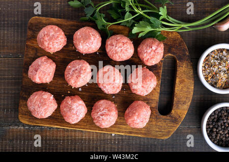 Materie polpette di carne su un tagliere, vista dall'alto Foto Stock