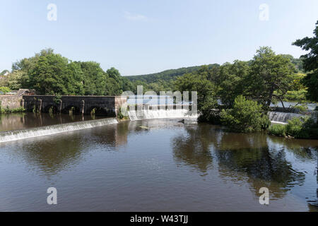 La weir e paratoie nel fiume Derwent adiacente al vecchio mulino edifici a Belper, Derbyshire, England, Regno Unito Foto Stock