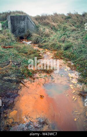 Effluente contaminato con metalli pesanti dai rifiuti sepolti, lo scarico nel fiume Thame, West Midlands, Regno Unito Foto Stock