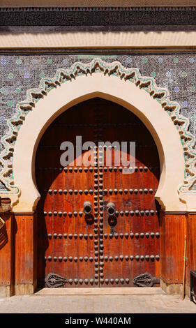 Il Marocco, Fez. Bella facciata e Arabesque portale ad arco e la piastrella vetrinata porta-surround con islamica pattern simmetrici nella vecchia medina. UNESCO Foto Stock