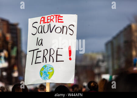 Una vista ingrandita di un francese della lettura del segno di avviso, salvare il pianeta. Tenuto da un attivista ecologico durante una strada pacifica protesta. Foto Stock