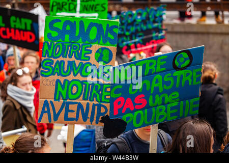 In casa francese cartelloni sono visti closeup in una strada affollata di attivisti ecologici. Un poster che dice a salvare il nostro pianeta a salvare il nostro futuro. Foto Stock