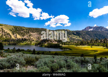 La luce del sole gioca tag attraverso le nuvole a gabbiano lago nel giugno lago ansa in California USA Foto Stock