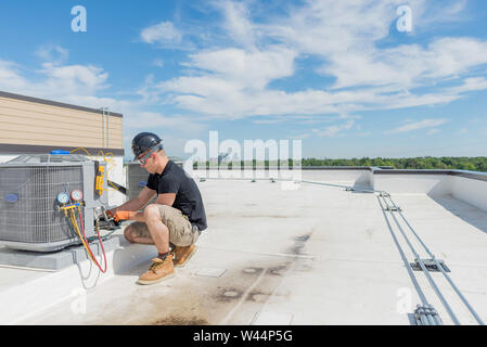 Hvac tecnico che lavora su un gruppo di climatizzazione con un sacco di spazio aperto Foto Stock