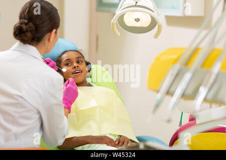 Dentista femmina in guanti asettici azienda strumenti per dentisti Foto Stock