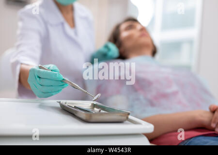 Dentisti in mano un guanto tenendo un mirror Foto Stock