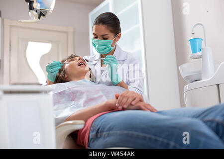 Focalizzato femmina professionale medico pazienti di controllo della salute dentale Foto Stock