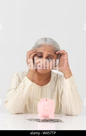 Donna delusa con la banca piggy Foto Stock