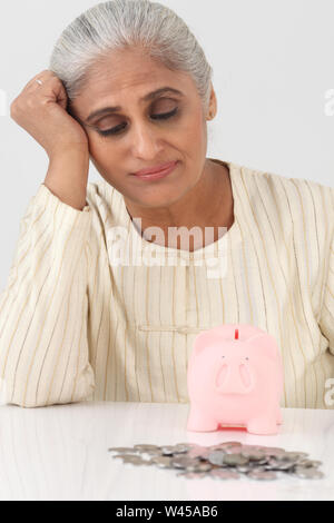 Donna delusa con la banca piggy Foto Stock