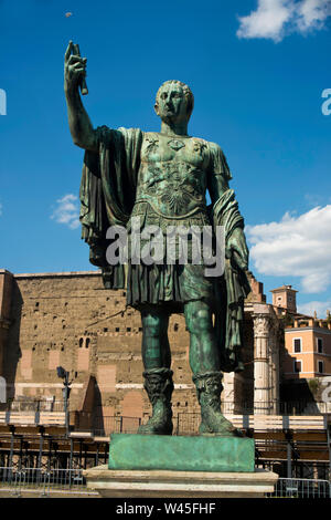 Statua in bronzo di fronte le rovine Romane, Roma. Foto Stock