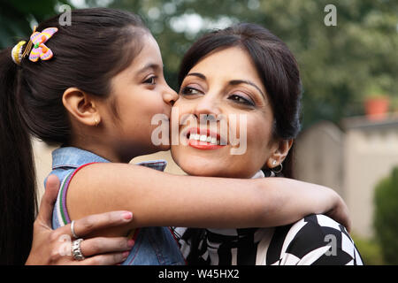 Figlia di madre il bacio sulla guancia Foto Stock