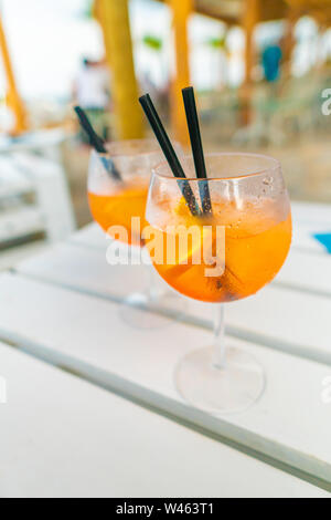 Deliziosa classic iced aperol spritz cocktail con cubetti di ghiaccio su una calda spiaggia tropicale in estate sole Foto Stock