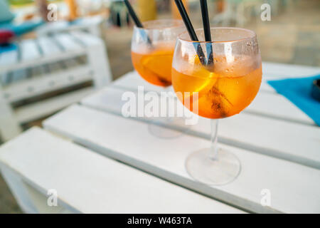 Deliziosa classic iced aperol spritz cocktail con cubetti di ghiaccio su una calda spiaggia tropicale in estate sole Foto Stock