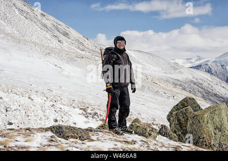 Gli escursionisti rimangono su una collina innevata e godono di una splendida vista. Foto Stock