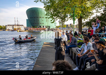 Amsterdam, Paesi Bassi, Boom Hannekes beer garden sul lungomare con una vista del Museo di Nemo, Foto Stock