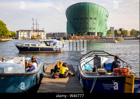 Amsterdam, Paesi Bassi, Boom Hannekes beer garden sul lungomare con una vista del Museo di Nemo, Foto Stock