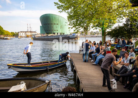 Amsterdam, Paesi Bassi, Boom Hannekes beer garden sul lungomare con una vista del Museo di Nemo, Foto Stock