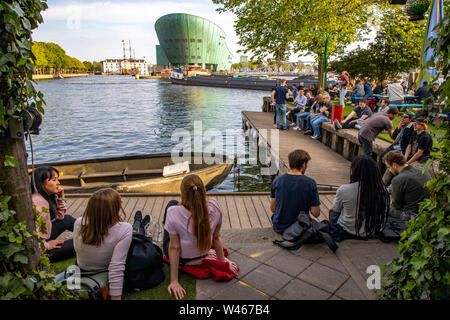 Amsterdam, Paesi Bassi, Boom Hannekes beer garden sul lungomare con una vista del Museo di Nemo, Foto Stock