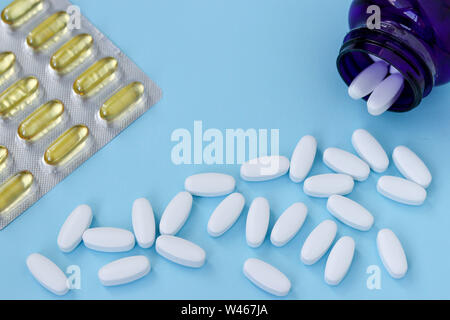 Vitamine per rafforzare le giunzioni, glucosammina e omega 3 su un fondo azzurro, vista dall'alto, la foto in orizzontale, spazio di copia Foto Stock