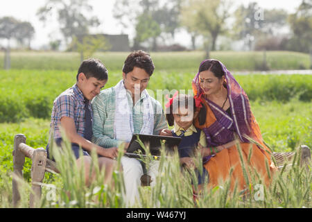 Famiglia rurale che utilizza un computer portatile Foto Stock