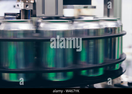 Vuoto nuove lattine in alluminio per bevande processo sono in movimento nella linea di fabbrica sul nastro trasportatore in corrispondenza della macchina di produzione di bevande il cibo e la bevanda industriale Foto Stock