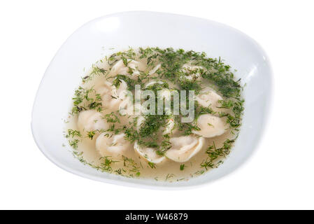 Gnocchi e prezzemolo con brodo - pelmeni russo - italiano ravioli su piastra bianca isolata Foto Stock