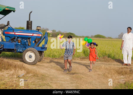 Brother and sister playing in a field Stock Photo