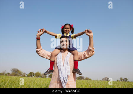 Uomo che porta la sua figlia sulle sue spalle Foto Stock