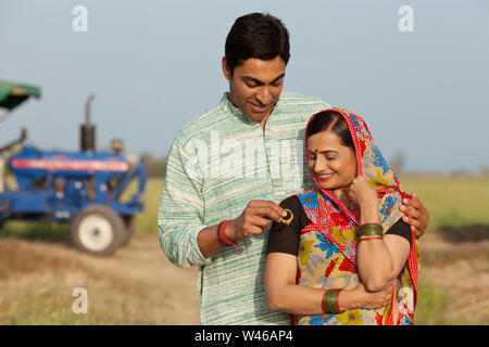 Uomo che dà orecchi a sua moglie Foto Stock