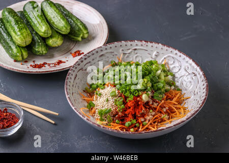 La preparazione di prodotti per la cottura tradizionale coreano kimchi cetriolo snack: miscelazione degli ingredienti in una piastra, alimento fermentato, la foto in orizzontale Foto Stock