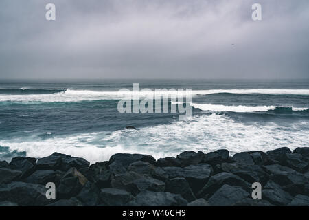 Azzorre, grandi onde che si infrangono sulla roccia vulcanica nera sull'Oceano Atlantico sulla costa dell'isola di Sao Miguel nelle Azzorre, Portogallo Foto Stock